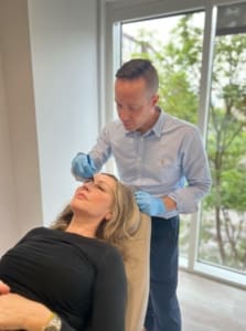 Aesthetic doctor preparing a patient for dermal filler treatment in London by drawing markings on the face